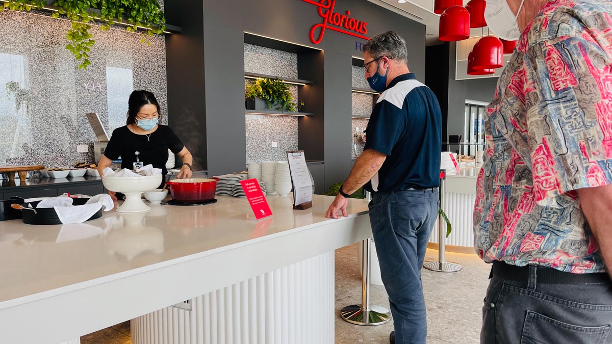 a man and woman wearing face masks at a restaurant counter