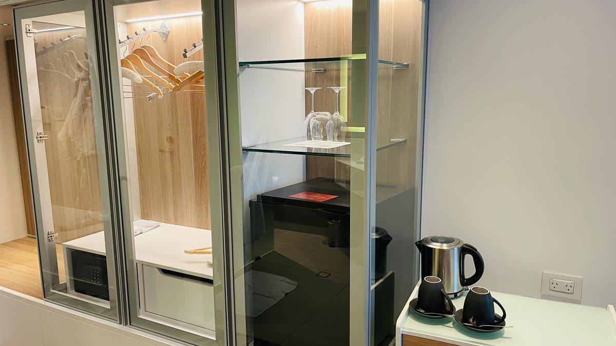 a glass cabinet with a shelf and a coffee pot