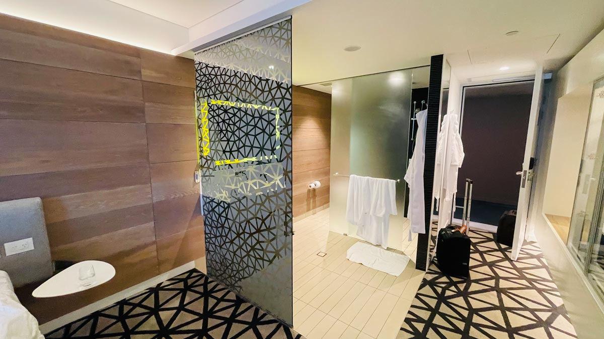 a room with a glass shower door and a black and white rug