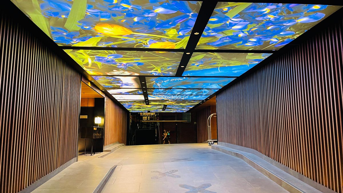 a walkway with a colorful ceiling