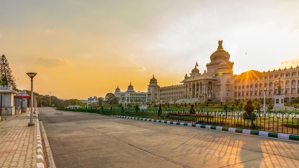 a road with a large building and a fence