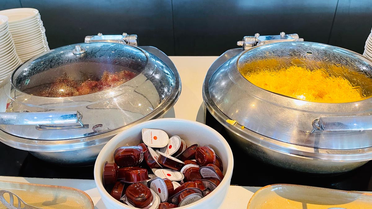 food in a buffet with bowls of condiments