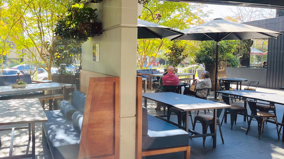 a group of people sitting at tables outside