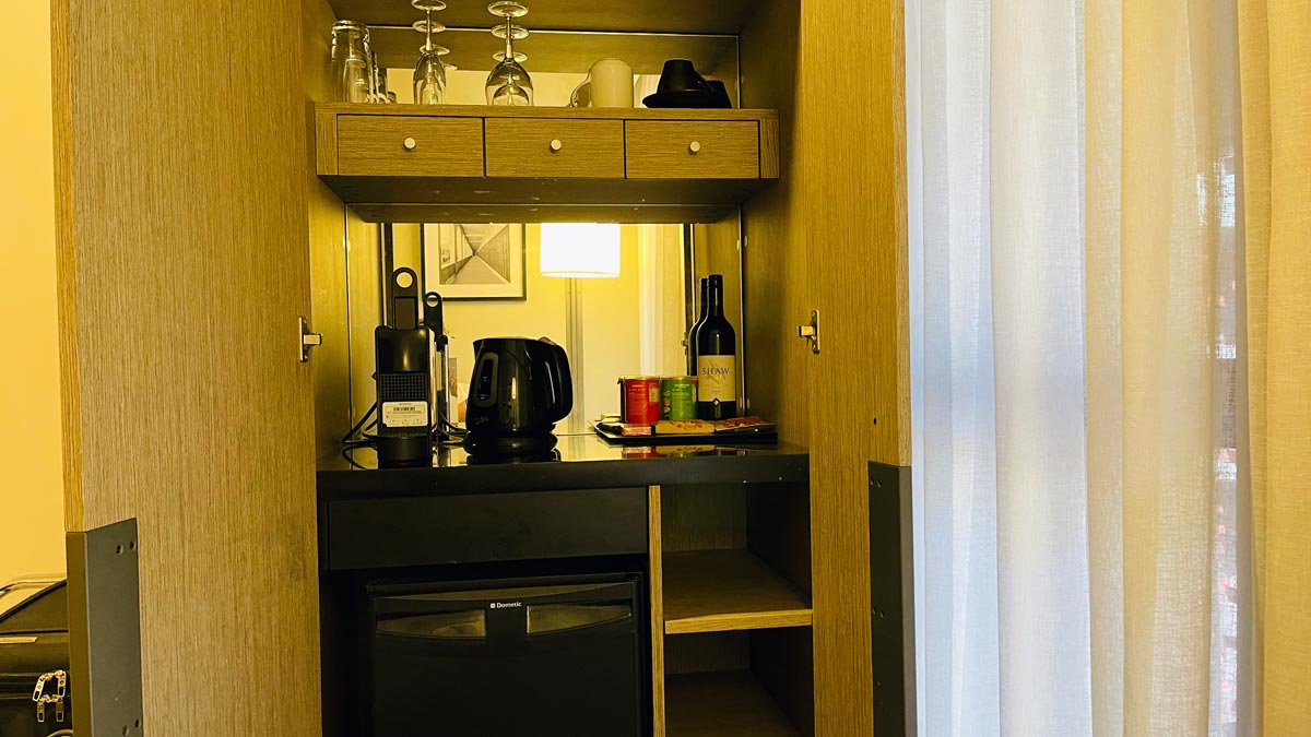 a kitchen counter with wine glasses and a microwave