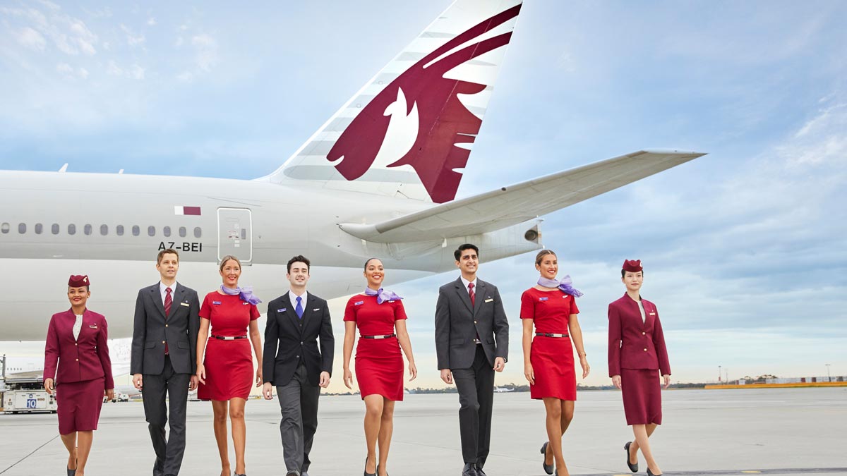 a group of people walking in front of an airplane