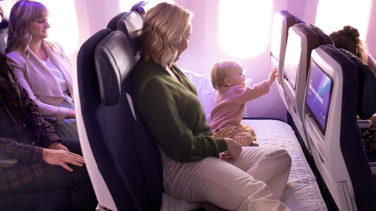 a woman and a child looking at a screen on an airplane