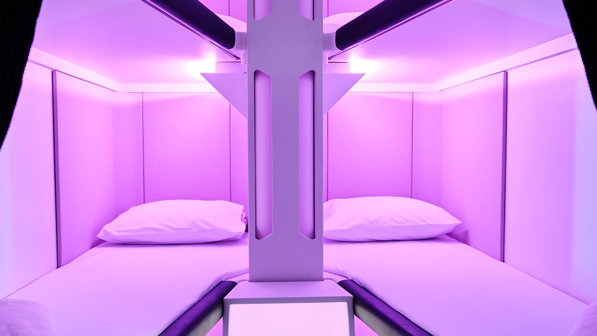 a room with two beds and purple lights