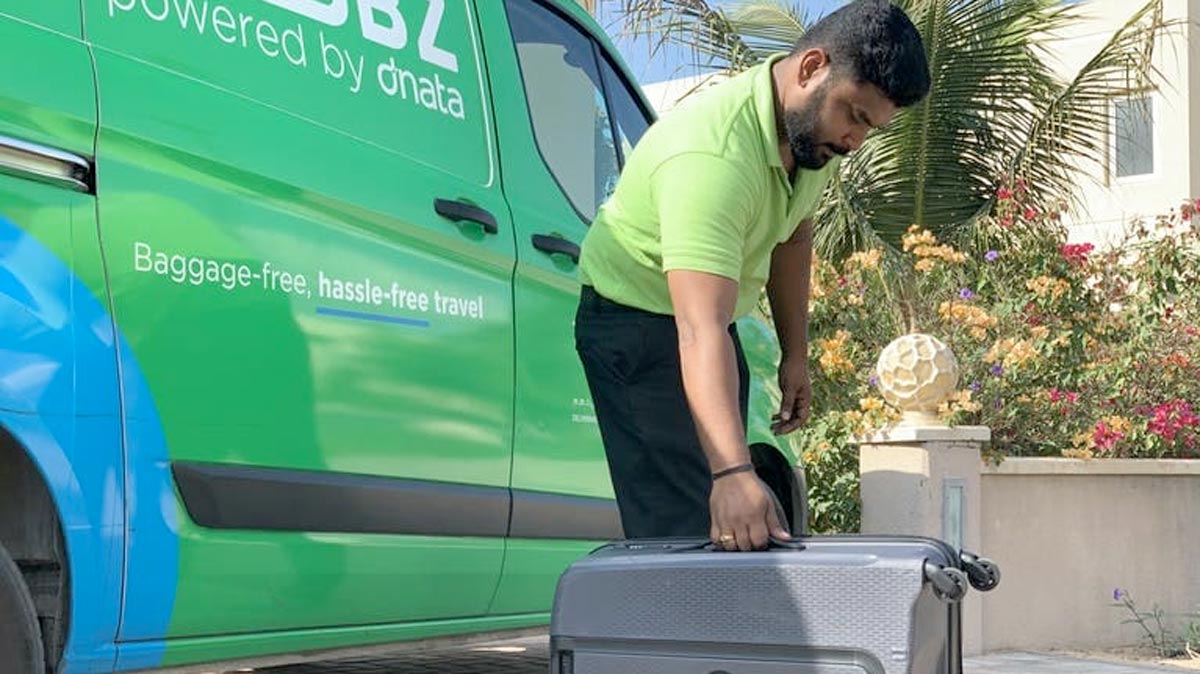 a man holding a suitcase next to a van