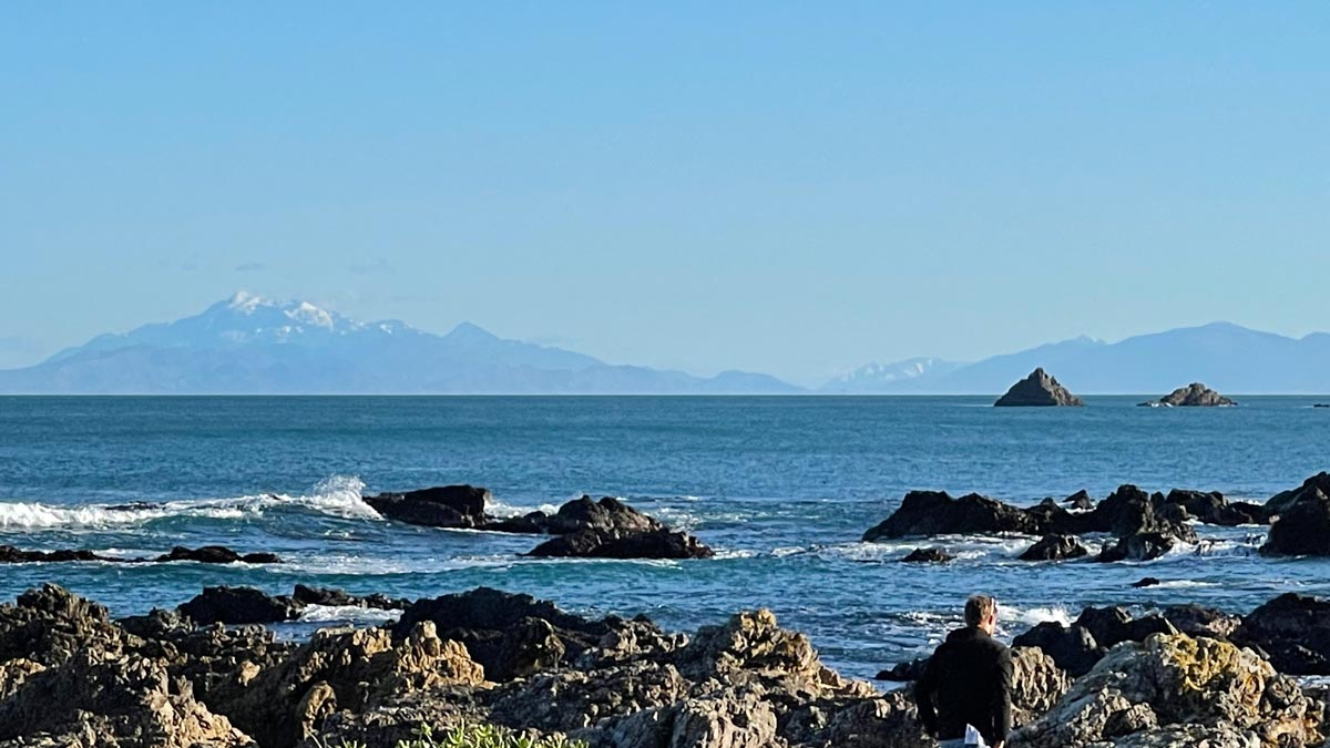 a man standing on rocks by the ocean