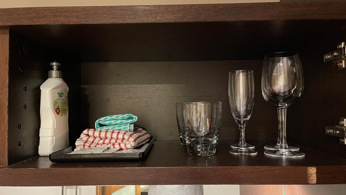 a shelf with glasses and napkins