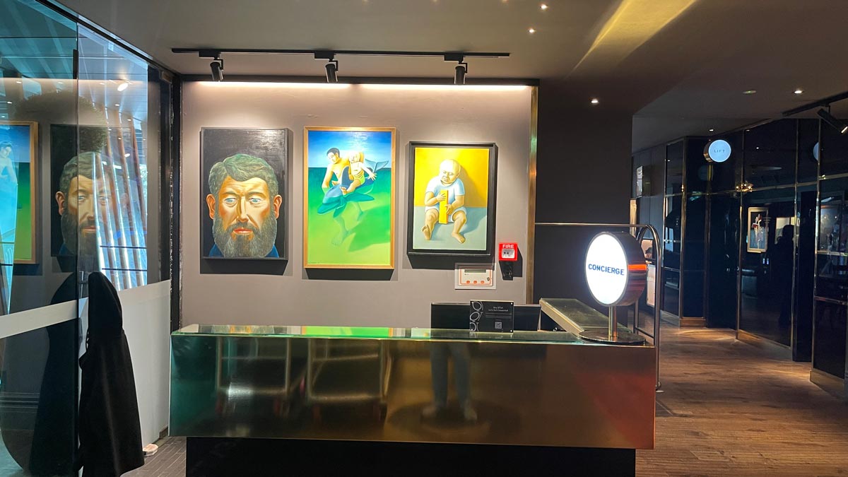 a reception desk with paintings on the wall