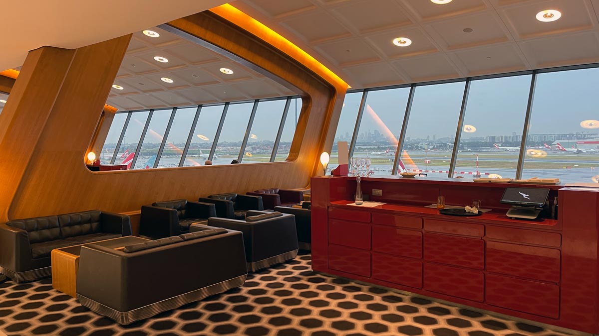 a room with a red counter and chairs