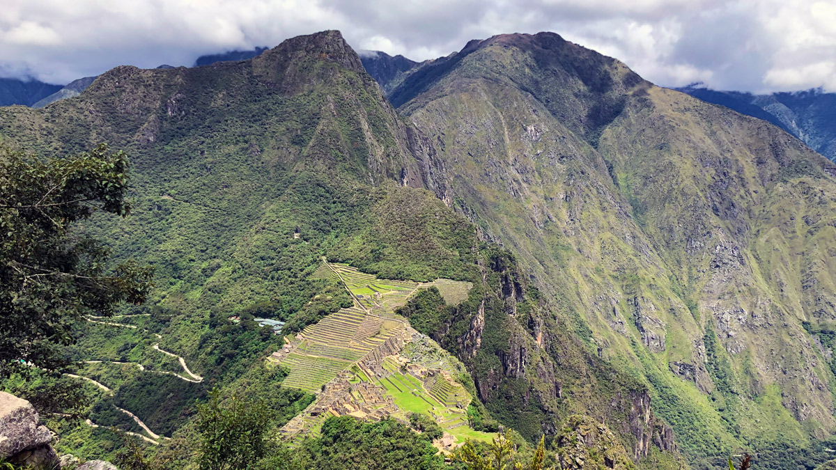 a green mountains with a stone structure