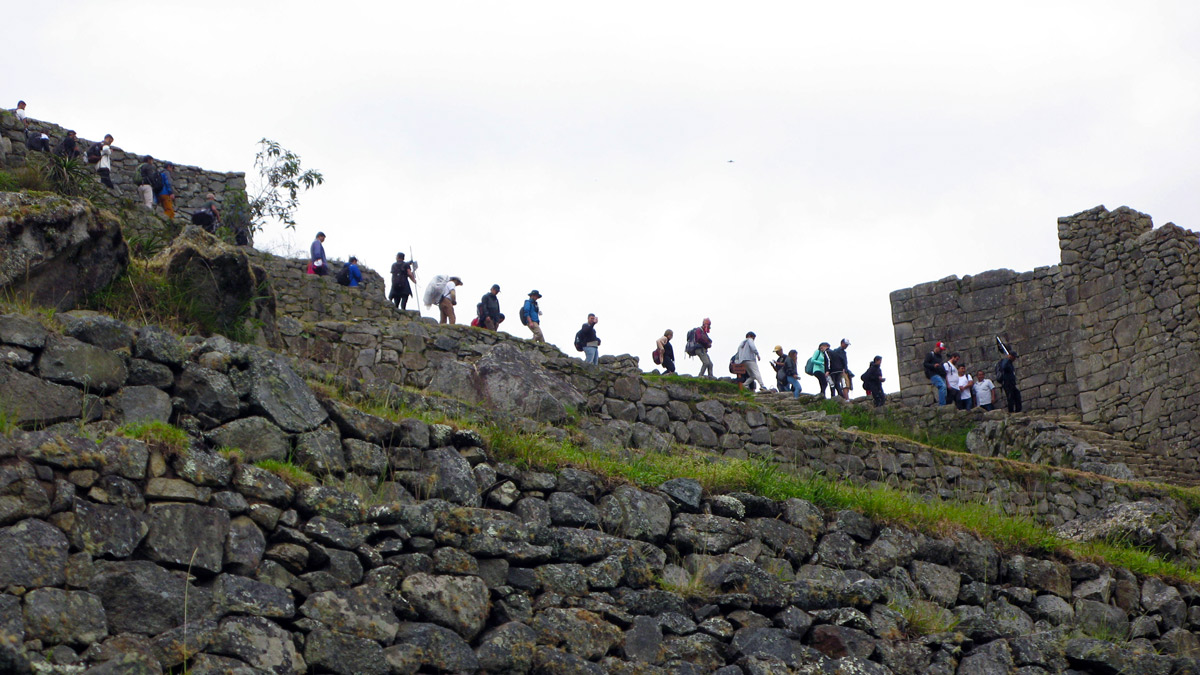 a group of people walking up a stone wall