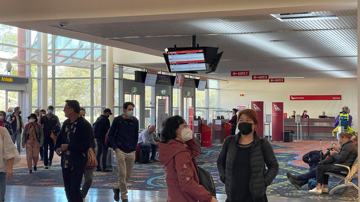 people in a terminal with people wearing face masks