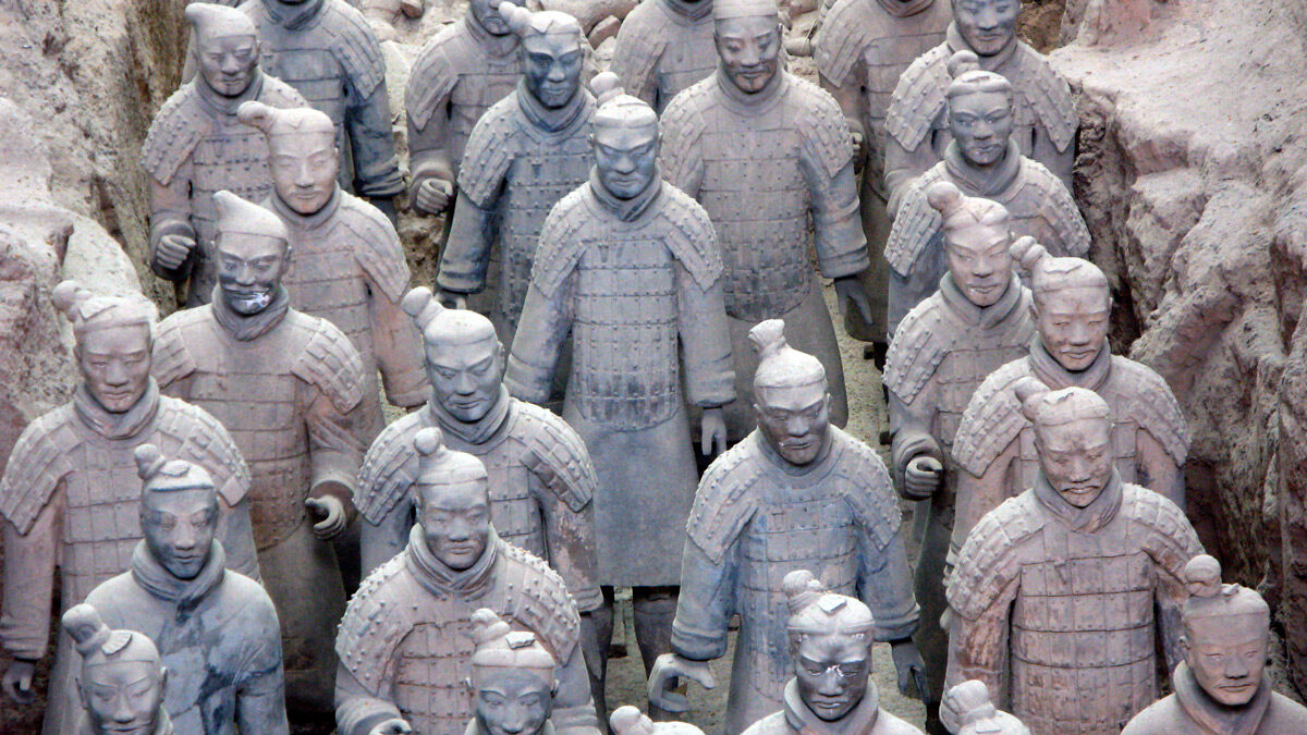 a group of statues of men with Terracotta Army in the background