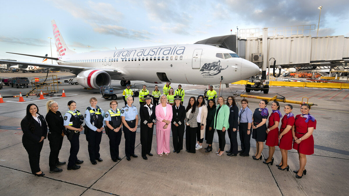 a group of people standing in front of a plane