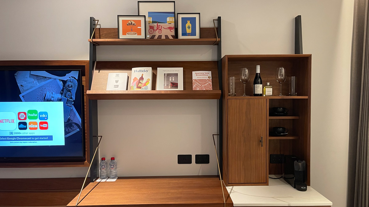 a shelf with a tv and wine bottles