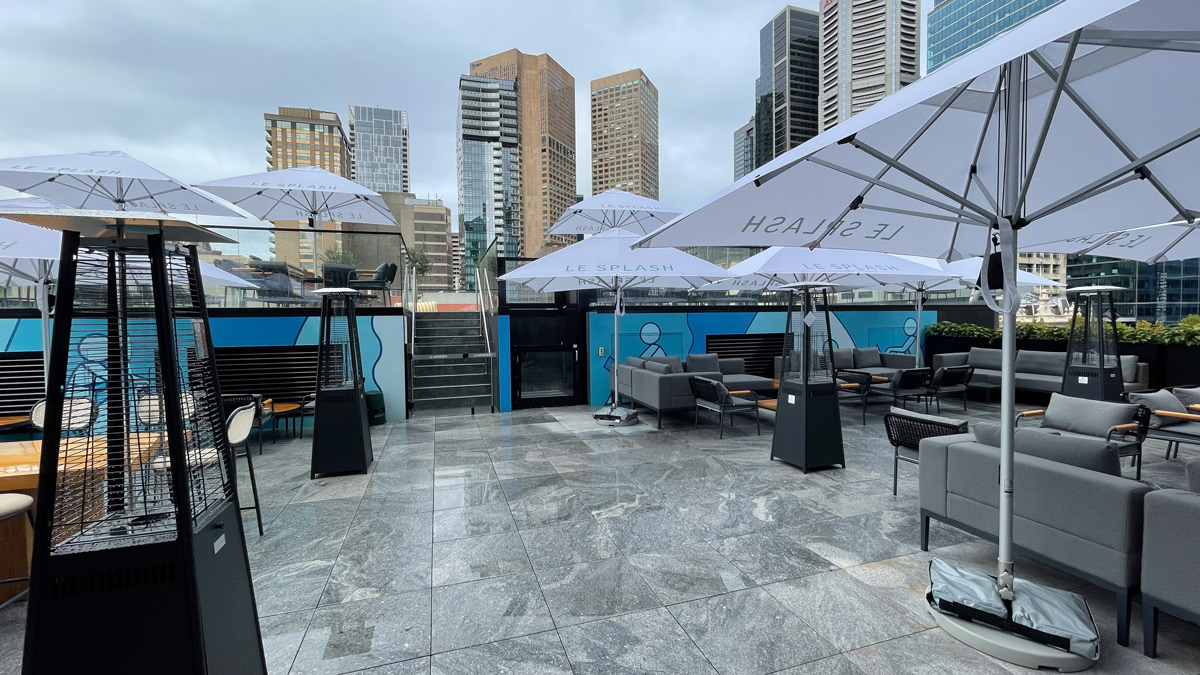 a patio with umbrellas and chairs in a city