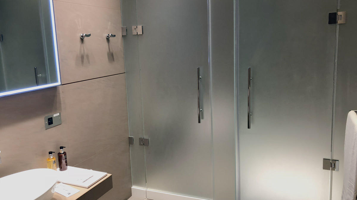 a glass shower door with silver handles