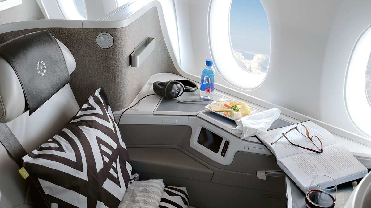 a tray of food and a bottle of water on a table in an airplane