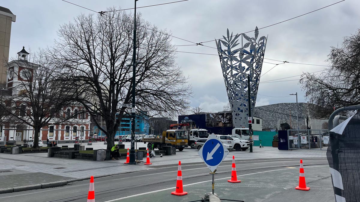 a street with traffic cones and a sculpture