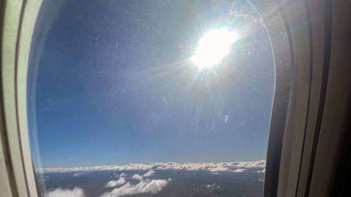 a view of clouds and the sun from a plane