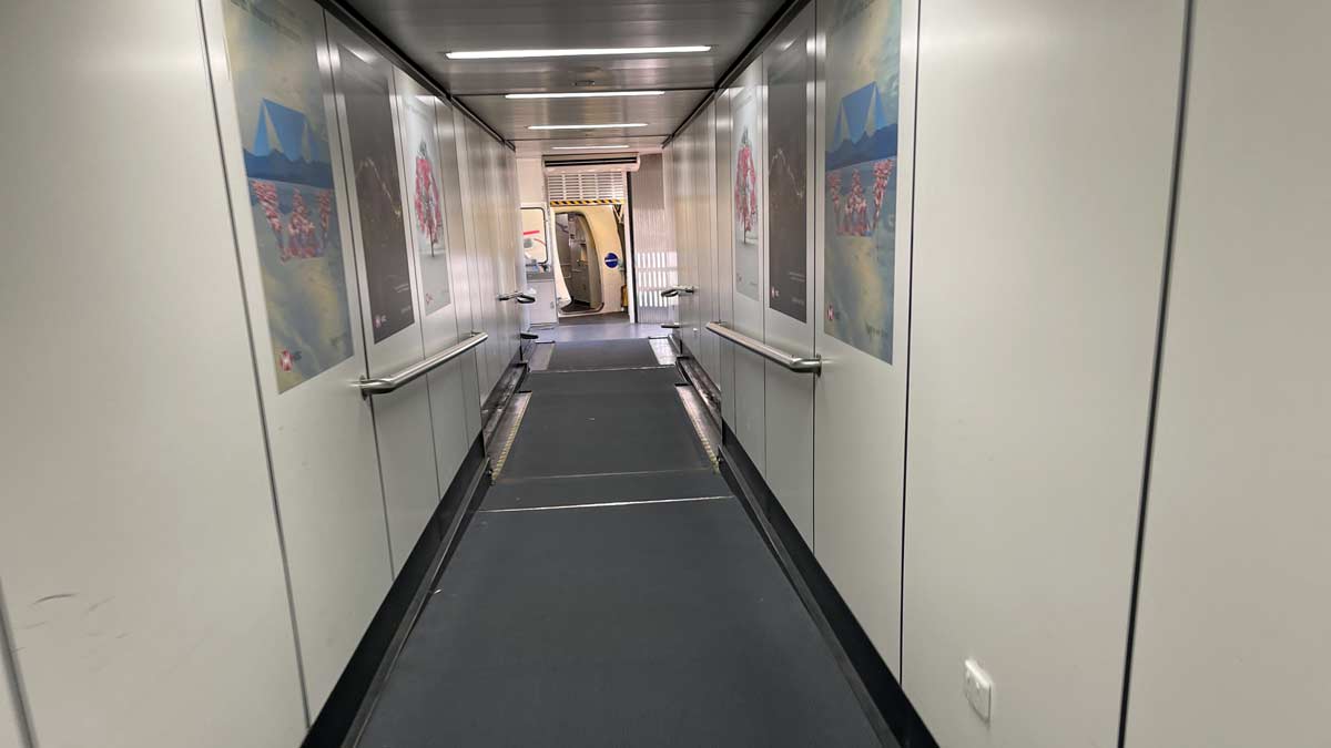a hallway with a walkway and posters on the wall