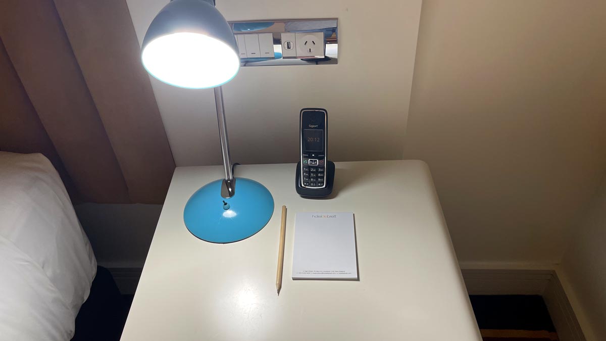 Bedside lamp, phone and pen and paper. Hotel DeBrett, Auckland New Zealand [Schuetz/2PAXfly]