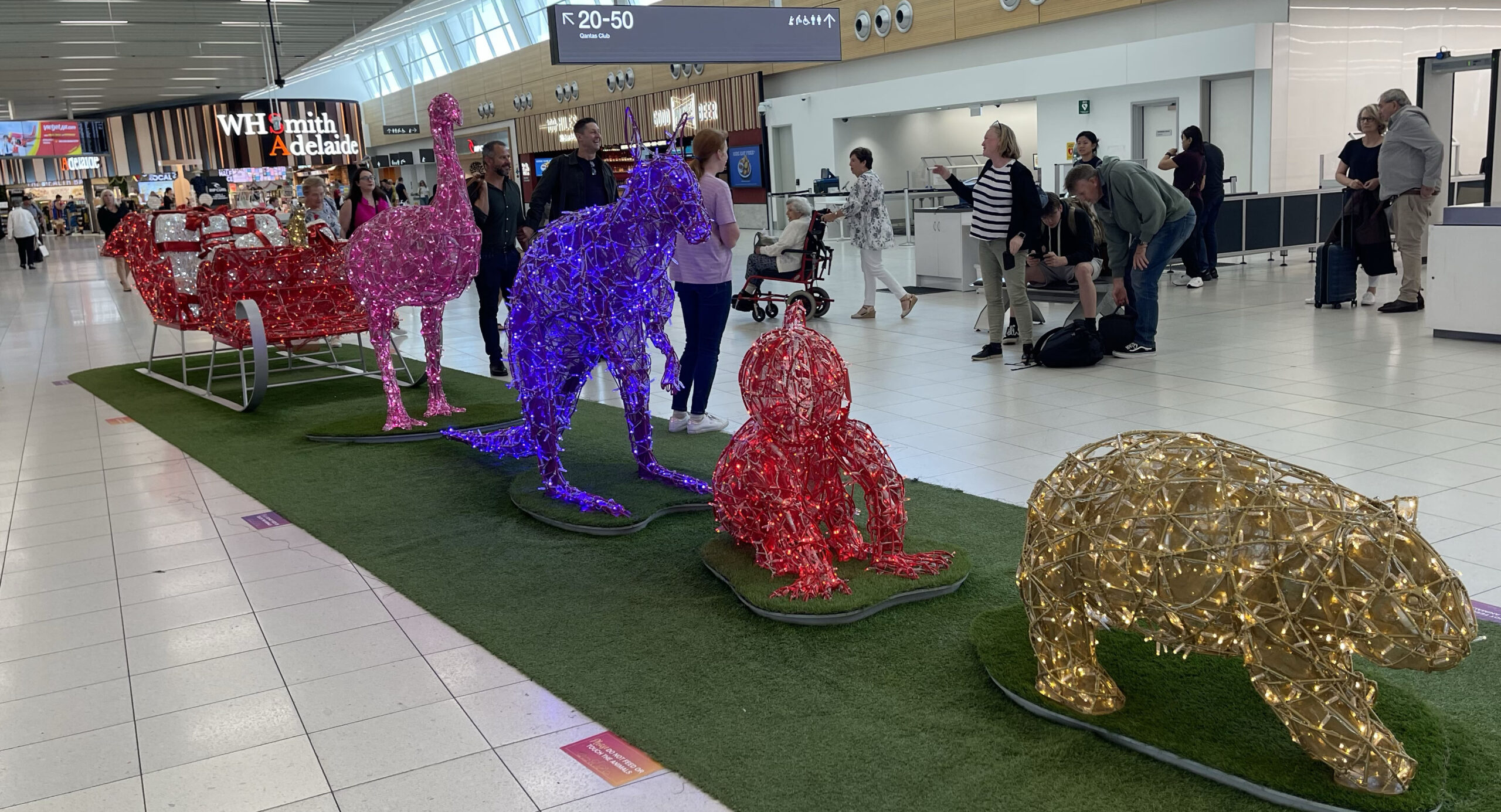 a group of people standing in a line with a group of animals