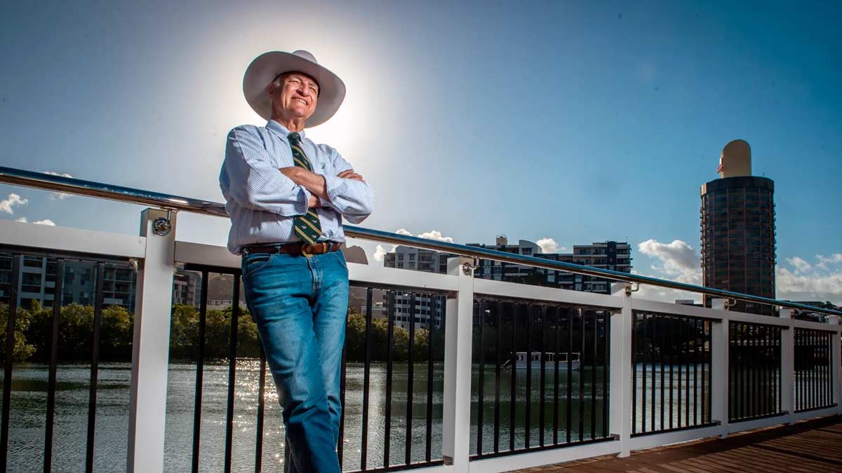 a man in a cowboy hat standing on a bridge