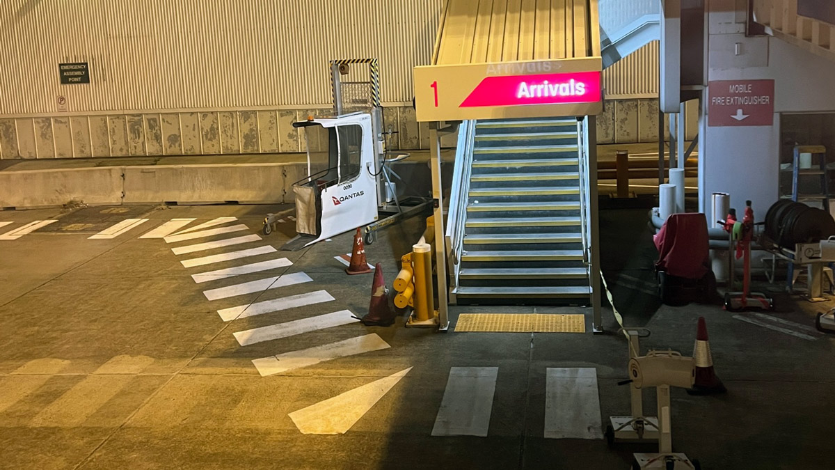 a white vehicle with a sign next to a staircase