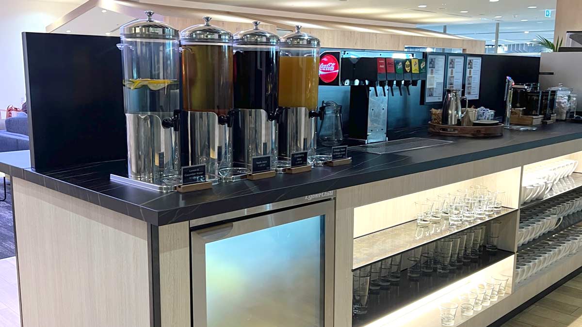 a row of drinks dispensers on a counter