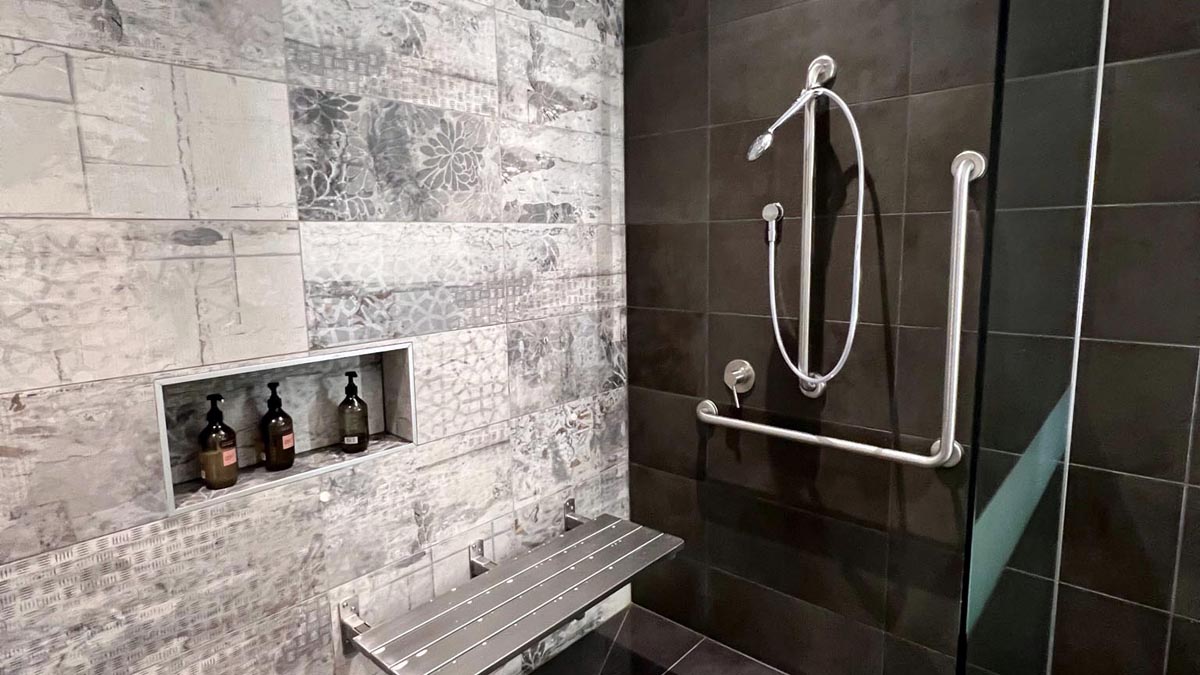 a shower with a bar and a shelf