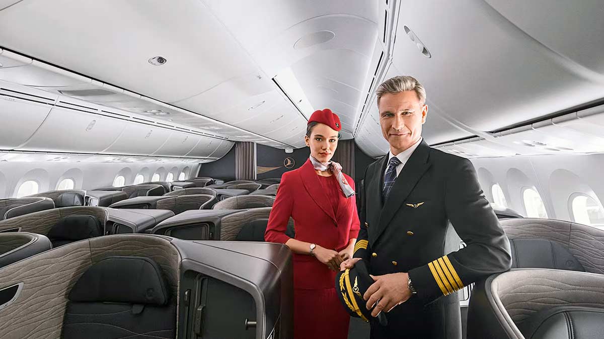 a man and woman in uniform standing in an airplane