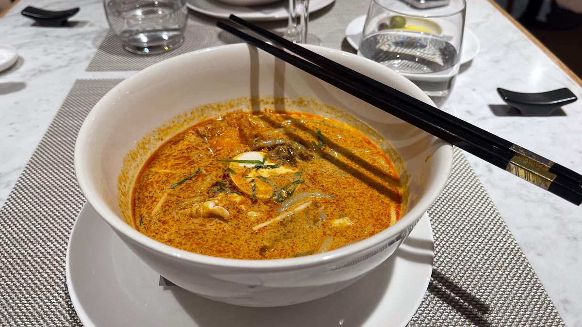 a bowl of soup with chopsticks