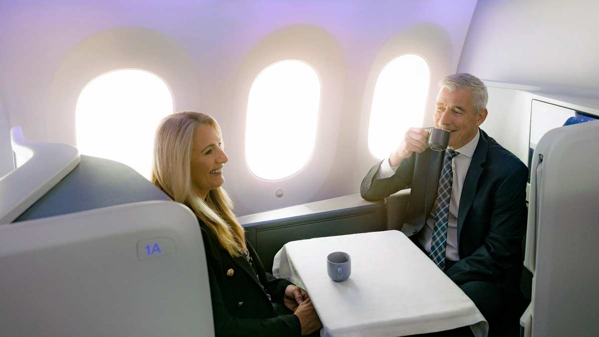 a man and woman sitting at a table in an airplane