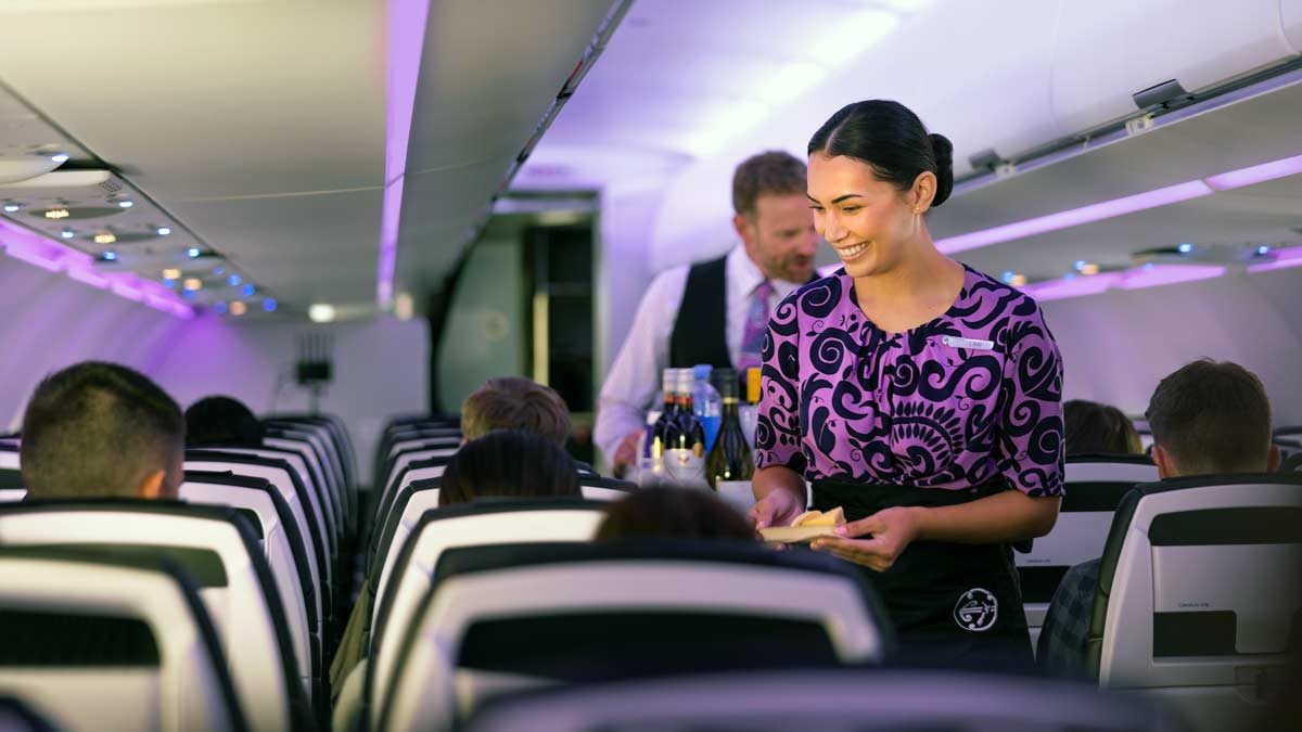 a woman serving food in an airplane