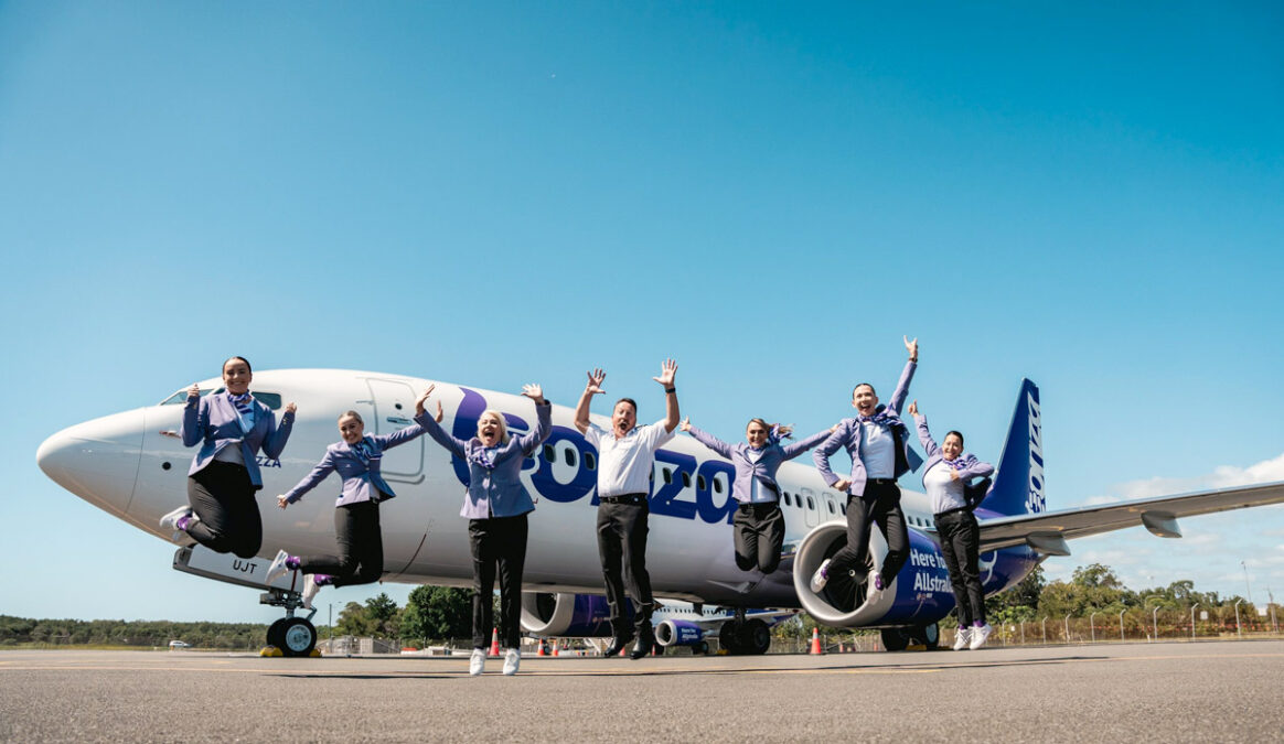 a group of people standing in front of a plane