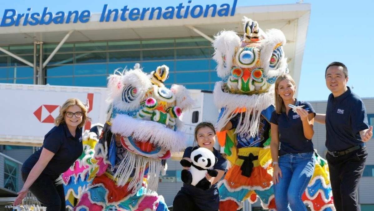 a group of people posing for a photo with a lion dance garment