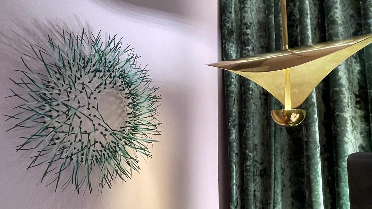 a wall lamp and a wall with a green curtain