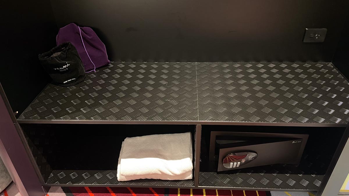 a shelf with a couple towels and a safe