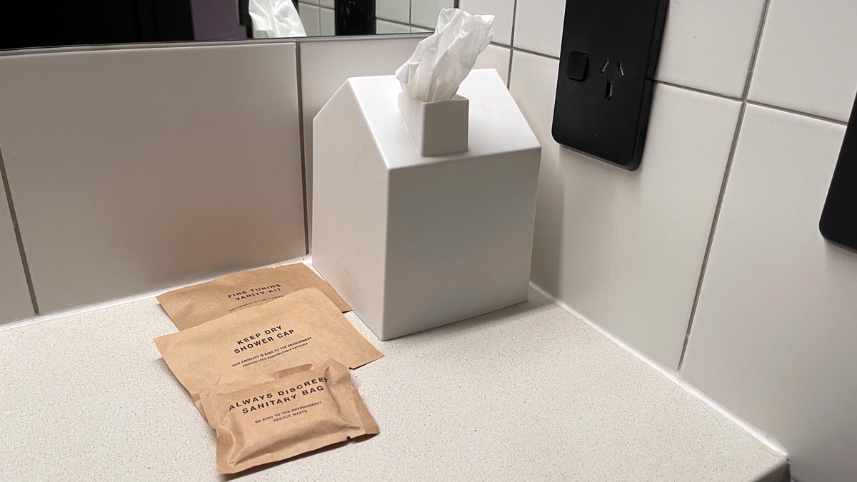 a tissue box in the shape of a house with the tissues coming out of the chimney on a counter