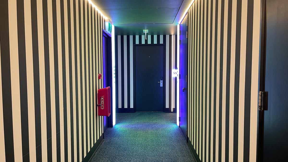 a hallway with a door and a fire extinguisher