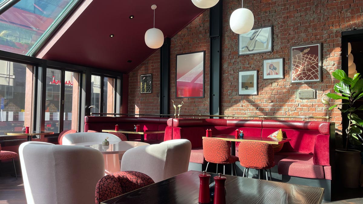 a room with a brick wall and tables and chairs