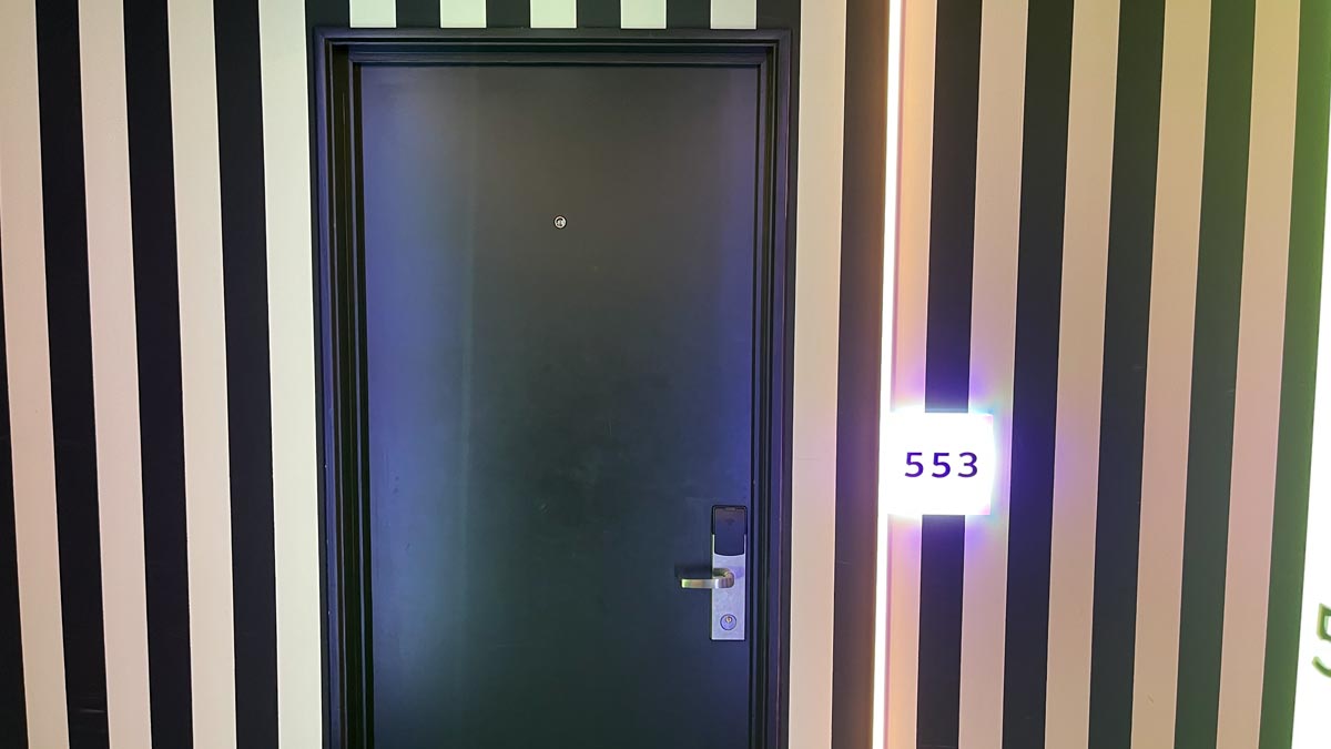 a black door with a white and black striped wall