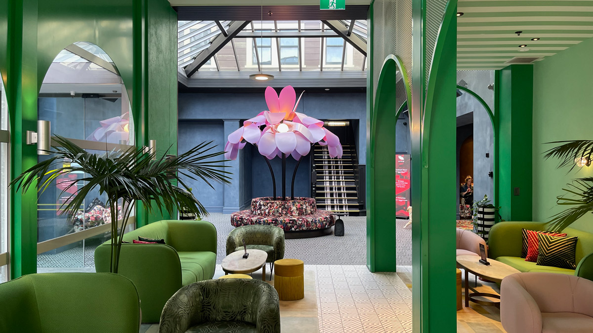 a room with green pillars and a flower lamp