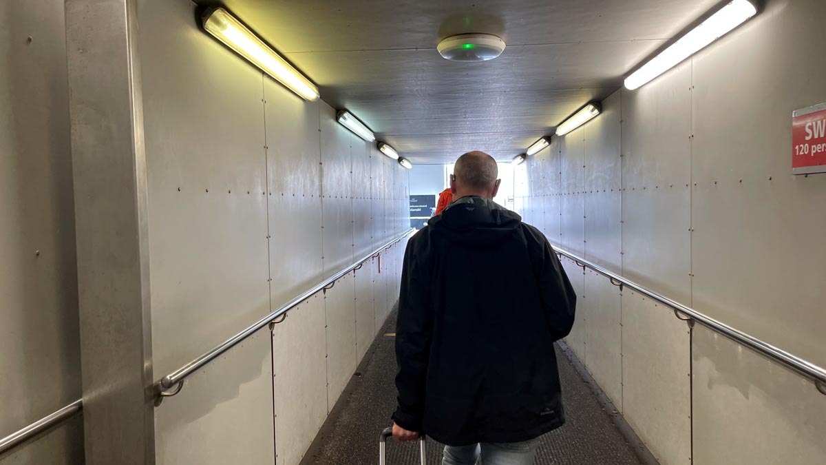 a man walking down a hallway with a luggage