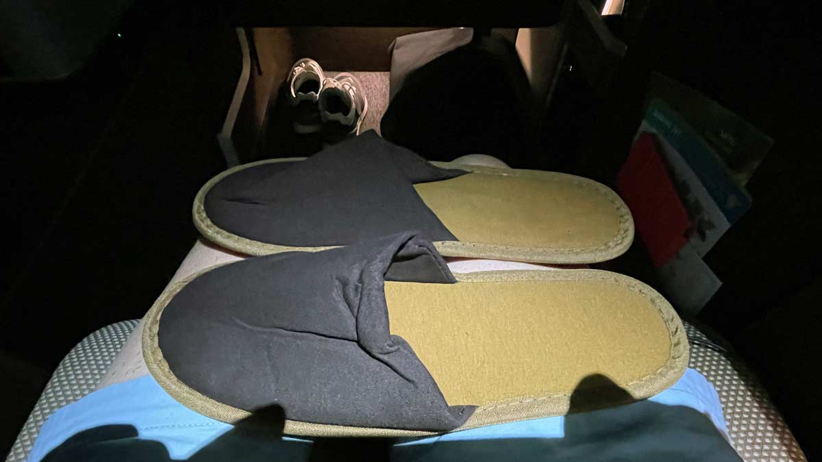 a pair of slippers on a bed