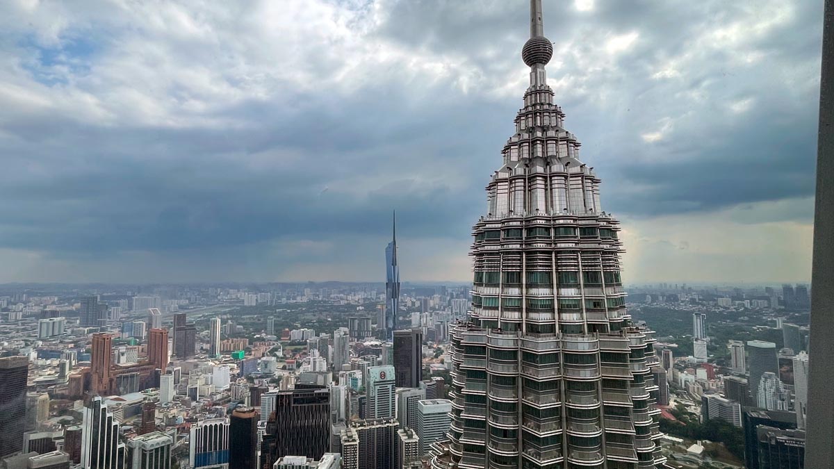 a tall building with a pointy top and a city in the background